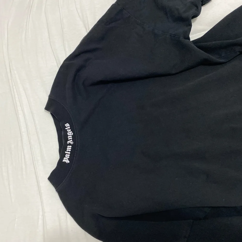 Säljer en svart t-shirt från Palm Angels med stor vit logga på ryggen och mindre logga i nacken. Klassisk passform och tillverkad i 100% bomull. Perfekt för dig som gillar streetwear och vill sticka ut med en ikonisk look. T-shirten är ganska tjock så kan även användas på sämre väder . T-paidat.