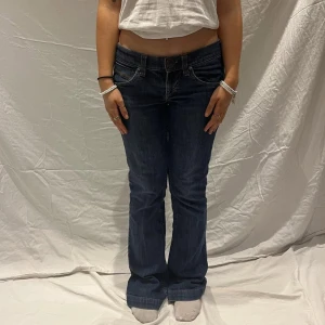 Lågmidjade, bootcut jeans från Miss Sixty - (Lånad bild) Mörkblåa Lågmidjade, bootcut jeans från Miss Sixty. Köpte secondhand av ett UF men i bra skick, lite defekter längst ner på byxorna pga av för långa så jag har trampat på dom, men ser ändå bra ut. Passar nog mellan stl S-M. 80-81 cm innerbenslängd. Om du har frågor eller vill ha mer bilder kontakta mig🩷