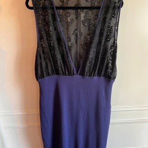 Blå klänning med spetsdetaljer från Even&Odd - Snygg blå klänning från Even&Odd med djup v-ringning och svart spetsdetalj på överdelen. Perfekt för en elegant look. Klänningen har en smickrande passform och är tillverkad i ett mjukt material.