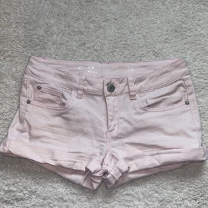 Ljusrosa jeansshorts low waist - Säljer ett par ljusrosa jeansshorts i modellen low waist. Shortsen har klassisk femficksdesign och uppvikta benslut. Jättefin rosa färg och i nyskick! Midjemåttet rakt över är 37 cm, men de är stetchiga. Kontakta mig för fler bilder eller vid intresse!💕