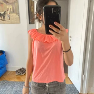 Korallrosa offshoulder topp med volang - Säljer en korallrosa offshoulder topp med bred volang runt armarna. Den är barnstorlek men passar mig som är s-xs 