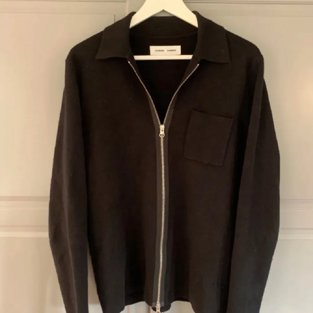 Stilren svart jacka från Samsøe Samsøe i ullmaterial. Jackan har klassisk krage, bröstficka och hel dragkedja framtill. Perfekt för lager-på-lager och enkel att matcha med olika outfits. Köpt för 1500 , bra skick . Takit.