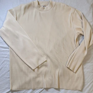 Beige ribbad långärmad tröja från Zara - Säljer en stilren beige ribbad tröja från Zara. Tröjan har lång ärm, rund halsringning och är tillverkad i ett mjukt material som ger en snygg struktur. Perfekt för lager-på-lager och enkel att matcha med olika outfits.