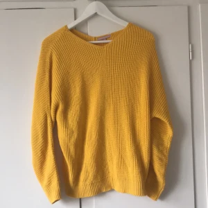 Gul stickad tröja - Säljer en härlig gul stickad tröja med rund hals och långa ärmar. Perfekt för att lysa upp garderoben med en färgklick. Tröjan har en avslappnad passform och ribbade kanter vid ärmslut och nederkant. Strl S