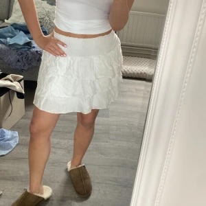 Vit volangkjol - Söt vit kortkjol med volanger och elastisk midja. 