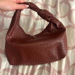 Vinröd väska  - Snygg vinröd väska, helt ny aldrig använd. 