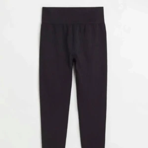 Svarta ribbade leggings - Snygga svarta ribbade leggings med hög midja. Perfekta för en stilren och bekväm look. Passar utmärkt till både avslappnade och mer uppklädda tillfällen. Använda en gång!