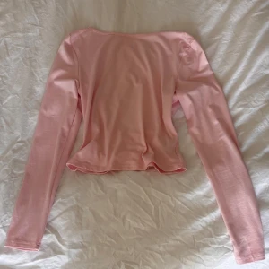 Rosa långärmad topp - Säljer en söt rosa långärmad topp med en öppen rygg. Denna är knappt använd, kanske 2-3 gånger. 