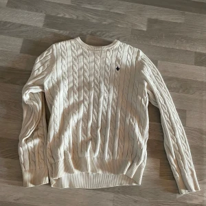 Vit stickad tröja från Morris - Säljer en stilren vit stickad tröja från Morris med kabelstickat mönster. Tröjan har långa ärmar och en liten broderad logga på bröstet. Storleken är S men har krympt lite så skulle säga mer som XS😊pris: 550kr