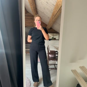 Svarta wide leg byxor från KappAhl Ellie - Säljer ett par svarta byxor från KappAhl, modell Ellie. Byxorna har hög midja och vida ben och är superfina och sköna. Jag har sprättat upp ett ben för att testa längden (sista bilden) men det är enkelt att antingen sprätta upp det andra eller sy upp ena benet igen. 🥰