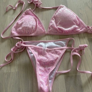 Rosa glittrig bikini - Snygg rosa bikini med glittriga paljetter och knytband. Perfekt för sommarens stranddagar. Tillverkad i polyester och elastan för en bekväm passform. Endast testad men passade inte mig. Storlek M men mer som en L. (Sista bilden lånad)