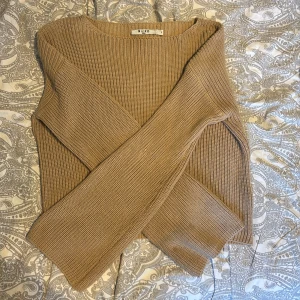 Beige stickad tröja från NA-KD - Säljer en snygg beige stickad tröja från NA-KD. Tröjan har en klassisk design med långa ärmar som blir större längre ner, och en rund halsringning. Mycket skönt material. Storlek S