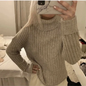 Beige ribbad polotröja - Säljer en mysig beige ribbad polotröja med långa ärmar. Perfekt för kyliga dagar och ger en stilren look. Passar bra till både jeans och kjol.
