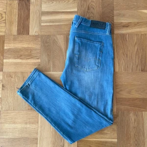 Replay anbass - Säljer nu ett par replay anbass. Snygga blå jeans från Replay med en klassisk femficksdesign. De har en normal passform och är perfekta för en avslappnad stil. Jeansen har en diskret tvättad. Storlek W33 L32. Litet hål i jeansen som ser ut som en slitning. Hojta till om ni har frågor