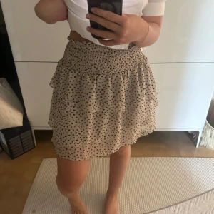Beige prickig volangkjol - Supersöt volangkjol från Hm!🖤 Kjolen är i storlek 170 men skulle säga den passar xs-m! Säljer pågrund av att den ej kommer till användning. 