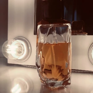 Lyxig parfym i geometrisk flaska - Säljer en elegant parfym i en unik, geometriskt formad glasflaska med guld rosa lock. Vätskan är ljus rosa och flaskan har en modern, stilren design som sticker ut på hyllan. Perfekt för dig som gillar exklusiva dofter och snygga detaljer.det är ca 80 ml kvar💗
