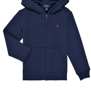 Mörkblå hoodie från Polo Ralph Lauren - Snygg mörkblå hoodie från Polo Ralph Lauren med dragkedja framtill och klassisk röd logga på bröstet. Tröjan har huva, kängurufickor och är tillverkad i mjuk bomullsmix. Perfekt för en chill och stilren look. St14-16år