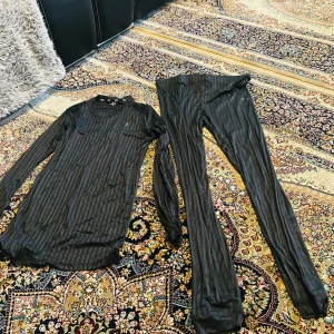 Svarta randiga underställset Nordanstig Lagar 157 - Svarta underställset från Nordanstig, Lagar 157 i storlek L, med diskret randigt mönster. Tillverkade i ett lätt och stretchigt syntetmaterial som andas, perfekta för lager-på-lager under kalla dagar. Säljs tillsammans med matchande långärmad tröja och praktisk förvaringspåse.