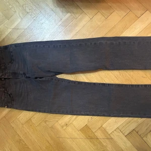 Levi's 501 svarta jeans W32 L34 - Klassiska svarta Levi's 501 jeans med raka ben och normal passform. Jeansen har fem fickor, knappgylf och är tillverkade i robust denim. Perfekta för dig som gillar en tidlös och clean look. Snygga kontrastsömmar och ikonisk läderpatch bak.