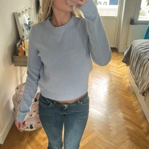 Ljusblå stickad tröja Brandy Melville - Superfin ljusblå stickad tröja från Brandy Melville. Tröjan har en croppad passform, rund halsringning och ribbade muddar vid ärmslut och nederkant. Perfekt att styla med jeans för en chill look.