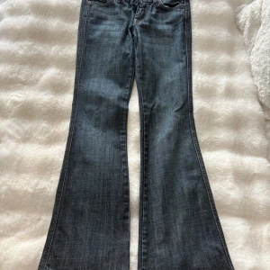 Bootcut jeans från 7 For All Mankind - Mörkblå bootcut jeans från 7 For All Mankind med klassisk femficksdesign och snygga detaljer på bakfickorna. Jeansen har låg midja och är tillverkade i mjukt denimtyg som sitter skönt hela dagen.