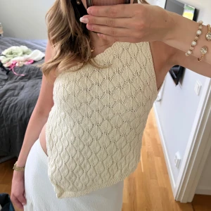 Stickad vit omlottopp med knyt🤍 - Supersöt stickad topp i vitt med snyggt mönster och omlottdesign. Toppen är ärmlös, har öppen rygg och knyts i ryggen för en trendig look. Perfekt till sommarens alla outfits och ger en fräsch vibe. Köpt från Zara och aldrig använd🤍 nypris 380kr