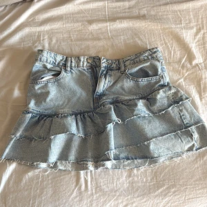 Jeanskjol med volanger från Gina tricot  - Supersöt ljusblå jeanskjol från Gina tricot med två volanglager. Perfekt för dig som vill ha en trendig och avslappnad look. Skriv för fler bilder 