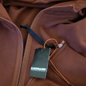 Vinröd hoodiejacka från cp company - Snygg vinröd hoodie från cp company med dragkedja framtill, huva med snörning och två fickor med dragkedja. Hoodie har en clean look och är tillverkad i mjukt bomullsmaterial. Perfekt för dig som gillar en avslappnad och stilren stil.