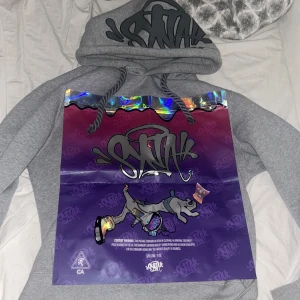 Syna world hoodie  - Centrals cee’s SynaWRLD märke. Grå hoodie med grå text. Storlek M Slim Fit passar även S