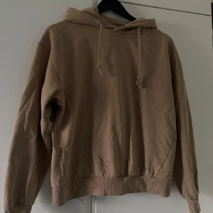 Beige hoodie från 157 i bomull XS - Säljer en beige hoodie från 157 i storlek XS. Tröjan har huva med snörning, ribbade muddar och är tillverkad i mjuk bomull. Perfekt för en chill och avslappnad stil. Passar dig som gillar neutrala färger och enkel design.