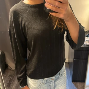 Svart långärmad tröja Gina Tricot XS - Enkel svart långärmad tröja från Gina Tricot i storlek XS. Tröjan har rund halsringning och är tillverkad i mjuk bomullsmix. Perfekt till jeans eller kjol för en clean och stilren look. Armarna är korta i modellen 