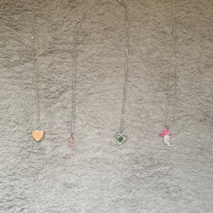 Halsband - Lite olika halsband vi har ett hjärta som e glittrigt som man även kan öppna och lägga i en bild i sen har vi ett gummibjörn från guldfynd sen har vi ett grön sten i och på självaste berlocket så står det ”I love you for always and forever” från guldfynd sedan har vi en sko med en rosa hatt och har fått det av en vän så vet inte alls vart hon har köpt den dem kosta 25kr st.