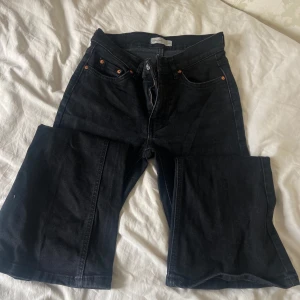 Svarta bootcut jeans  - Säljer ett par svarta jeans från Gina i storlek 34. Jeansen har bootcut-modell med breda ben och klassiska fem fickor. Snygga kopparfärgade nitar och dragkedja framtill. Perfekta till sneakers eller boots. 