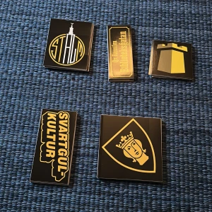 AIK klibbor - En bok med svart och gul design, fylld av symboler och grafiska motiv kopplade till Stockholm och dess kultur. Perfekt för dig som gillar stilrena illustrationer och vill utforska stadens identitet på ett unikt sätt.