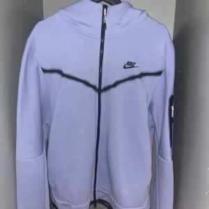 Ljuslila Nike Tech Fleece XL - Ljuslila Nike Tech Fleece med svarta detaljer och dragkedja hela vägen.