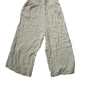 Beiga vida linnebyxor från H&M - Säljer ett par beiga linnebyxor från H&M i storlek M. Byxorna har resår i midjan, är vida i modellen och tillverkade i ett lätt och luftigt linnematerial. Perfekta för en chill och avslappnad stil under varmare dagar.