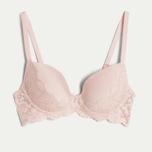 Rosa spets-bh - Säljer en söt rosa bh med spetsdetaljer. Den har justerbara axelband och en mjuk kupa. Knappt andvänd. 