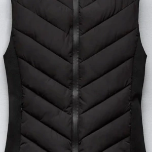 Svart dunväst med dragkedja - Snygg svart dunväst med dragkedja framtill och diskret mönster i form av sneda sömmar. Perfekt att slänga över en hoodie eller tröja för extra värme. Västen har en stilren och sportig look. Säljer för den kommer en t användning.