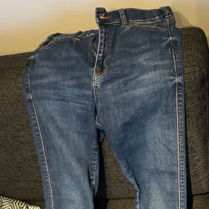 Blå skinny jeans från Dr Denim - Säljer ett par blå skinny jeans från Dr Denim, modell Lexy i färgen Atlantic Deep Blue. Jeansen har klassisk femficksdesign, smal passform och normal midja. Perfekta för dig som gillar stretchiga och bekväma jeans.