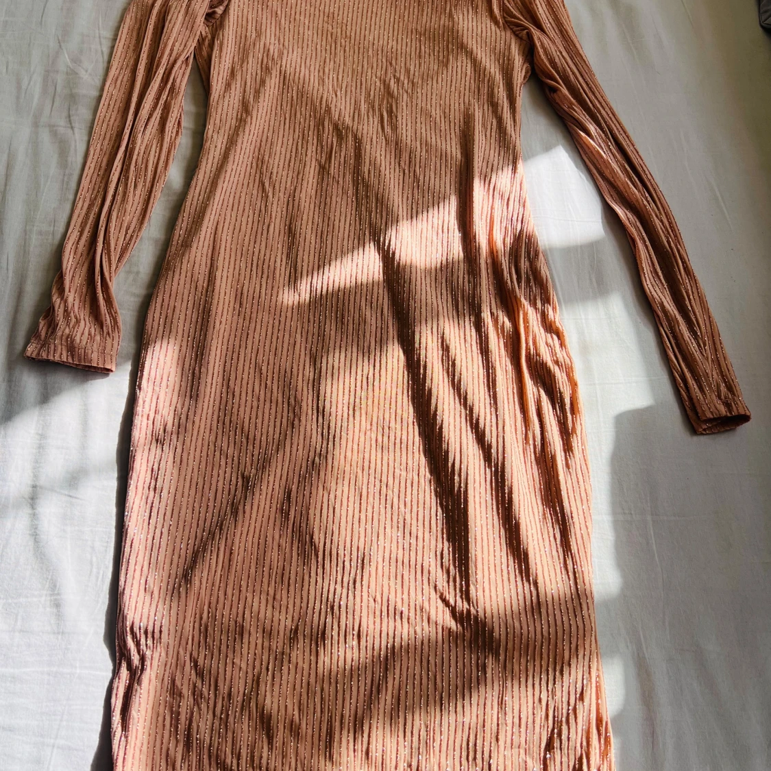 Glittrig långklänning i persikoton