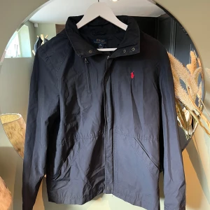 Ralph Lauren vindjacak - Säljer en skitsnygg vindjacka från Ralph Lauren i mörkblå färg! Perfekt till sommaren☀️Mycket bra skick också! Passar M och S
