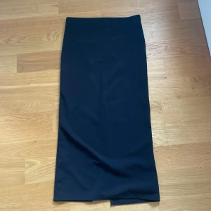 Svart långkjol - En svart stilren slimmad långkjol. Den är i storlek xs och är 85 cm lång. Köpt för 150 kr. Den har en resor i midjan, vilket gör att den är stretchig. Den har en slits där bak som gör det enkelt att gå. 💗