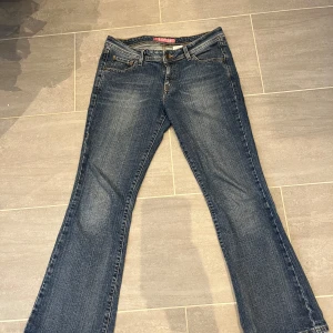 Levi's 518 blå jeans bootcut - Klassiska blå Levi's 518 jeans med bootcut. Jeansen har fem fickor, gylf med knappar och synliga kontrastsömmar. Tidlös modell med normal passform och hög midja. 