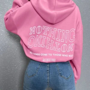 Rosa hoodie med tryck - Säljer en oversized rosa hoodie med vit text på ryggen. 