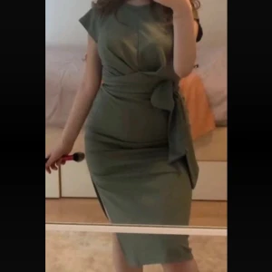 Olivgrön midiklänning med knytband bubbleroom - Snygg olivgrön klänning med knytband i midjan och korta ärmar från Bubbleroom i storlek XS. Klänningen har en figurnära passform och en stilren design som passar perfekt till olika tillfällen.