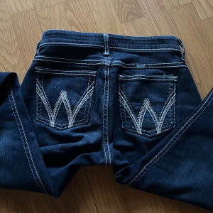 Mörkblå bootcut jeans från Wrangler - Säljer ett par mörkblå jeans från Wrangler. Helt nya, använda en gång. Lågmidjade och bootcut! Midjemått: 34cm tvärs över. Innerbenslängd: 80cm. Strech i midjan, passar mig som har storlek 34-36/ w 26-27. Skriv för fler bilder/ prisförslag 💞