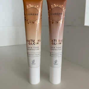 Lumene Natural Glow Skin Tone Perfector - Två tuber Lumene Natural Glow Skin Tone Perfector i nyanserna Honey Glow och 2 Perfect Tan. Flytande formula i beige och brun ton, ger lyster och jämnar ut hudtonen. Vegansk produkt, ca 10-15 ml per tub. Köp båda för 79 kr. 