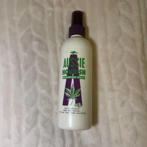Aussie Nourish Detangling Spray - Aussie Nourish Detangling Spray. Sprayen kommer i en vit plastflaska med lila spraymunstycke och gröna/lila detaljer. Perfekt för att reda ut håret och ge näring.