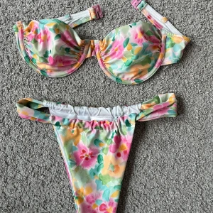 Blommig bikini från Gina Tricot - Säljer en färgglad blommig bikini från Gina Tricot i storlek XS. Bikinin är aldrig använd, då den inte passade, men tyvärr han jag ta av prislapparna. Bikinin har vadderad bygel-bh och matchande trosa med höga skärningar. Perfekt för sommardagar vid stranden!🌸🌸