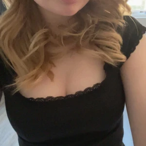 Svart ribbad topp med spetskant - Säljer en svart ribbad topp med söt spetskant längs urringningen. Toppen har korta ärmar och en figurnära passform som framhäver siluetten. I använt men bra skick. 💗